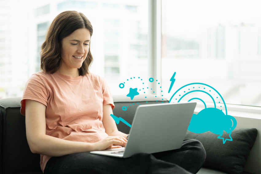 A woman sits on a gray couch with her laptop on her lap. She has shoulder-length wavy brown hair and wears dark jeans and a peach-colored top. There are windows behind her with high-rises in the distance. There are illustrated elements in blue around her laptop, including stars, lightning bolts, and a rainbow with a cloud.