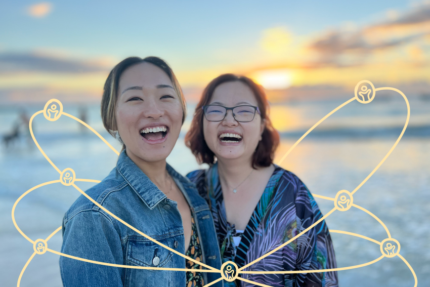 Chicago Minds' Founders Tracy De and Tianni Wang share a laugh on the beach as the sun sets. Tracy wears a jean jacket over a tank top and Tianni wears a dress with peacock feathers on it. An illustration of yellow loops surrounds them, showcasing a network of tiny outlines of people)